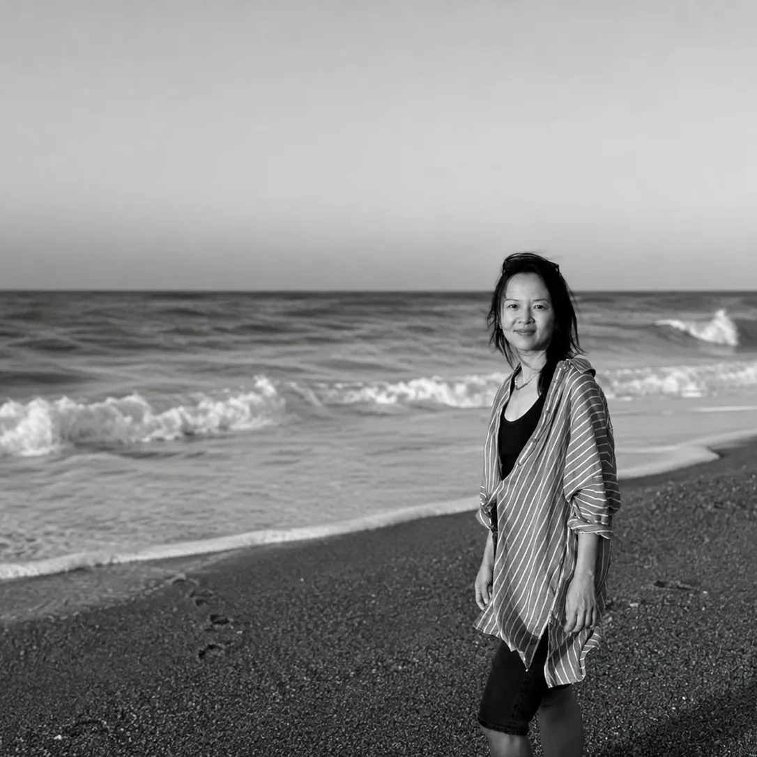 Mia Pang on a beach in Greece, black and white.